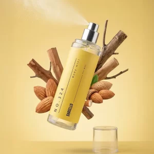 Bargello Body Mist 324 inspiré de Good Girl, présenté dans un flacon jaune avec vaporisation visible, entouré d’amandes et d’éléments boisés. Pour femme.