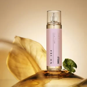 Bargello Body Mist 384 femme inspiré de Bombshell, présenté dans un flacon rose poudré sur un décor lumineux et raffiné.
