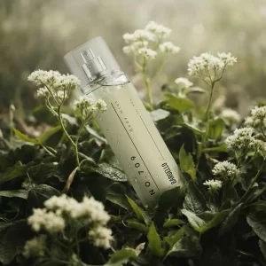 Bargello Body Mist 709 inspiré de Stronger with You, présenté dans un flacon élégant au milieu de fleurs blanches et de feuillage vert.